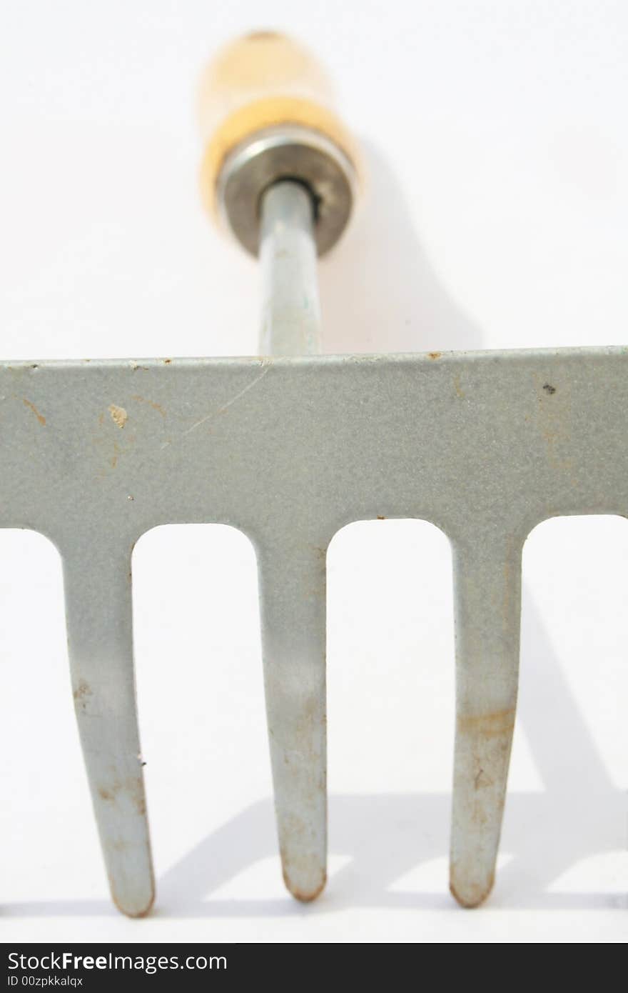 Hand rake on white background with shallow depth of field