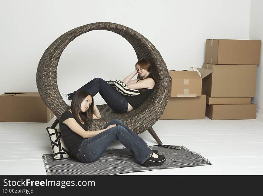 Two friends resting after moving boxes into a new apartment. Two friends resting after moving boxes into a new apartment.