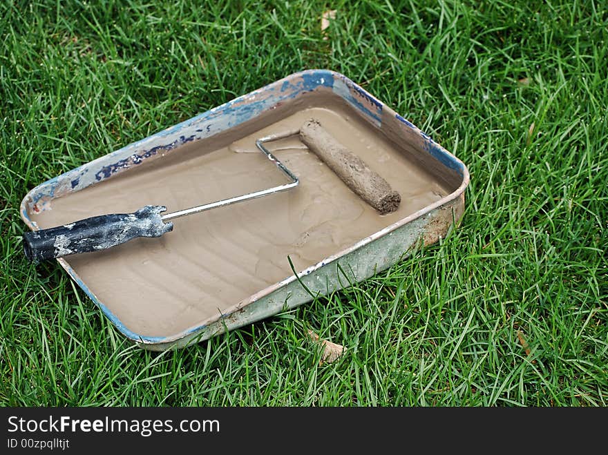 Saturated paint roller in a paint tray. Saturated paint roller in a paint tray.