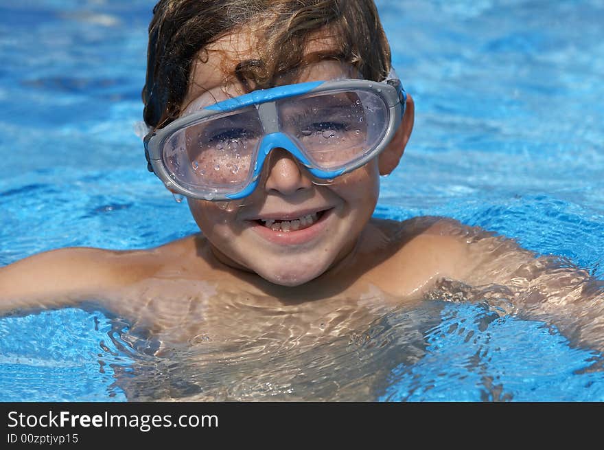 A young boy in pool with goggles on. A young boy in pool with goggles on