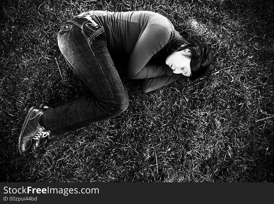 Young beauty sleeping over the grass, black and white toned. Young beauty sleeping over the grass, black and white toned.