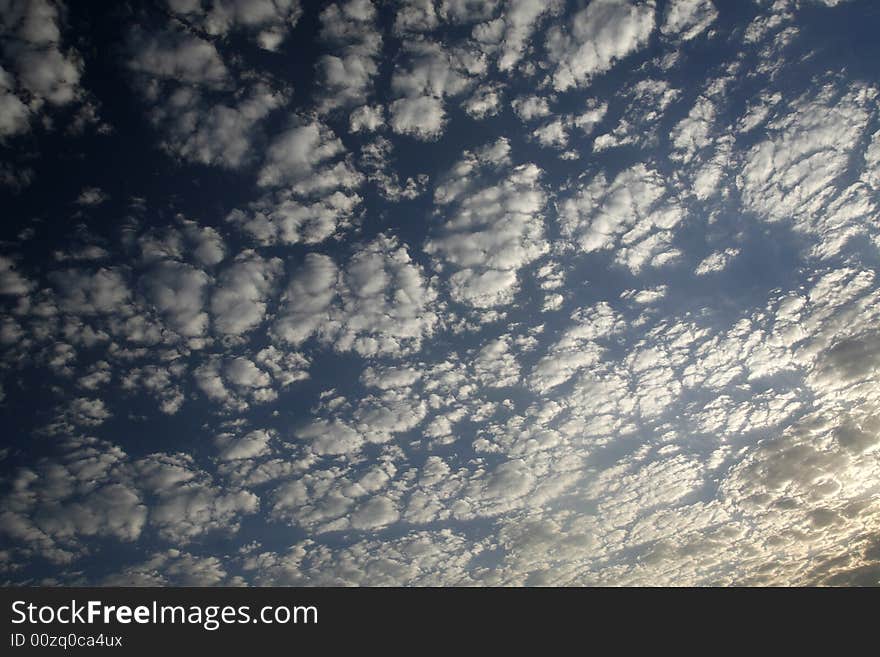 Blue sky with little white clouds at sunset