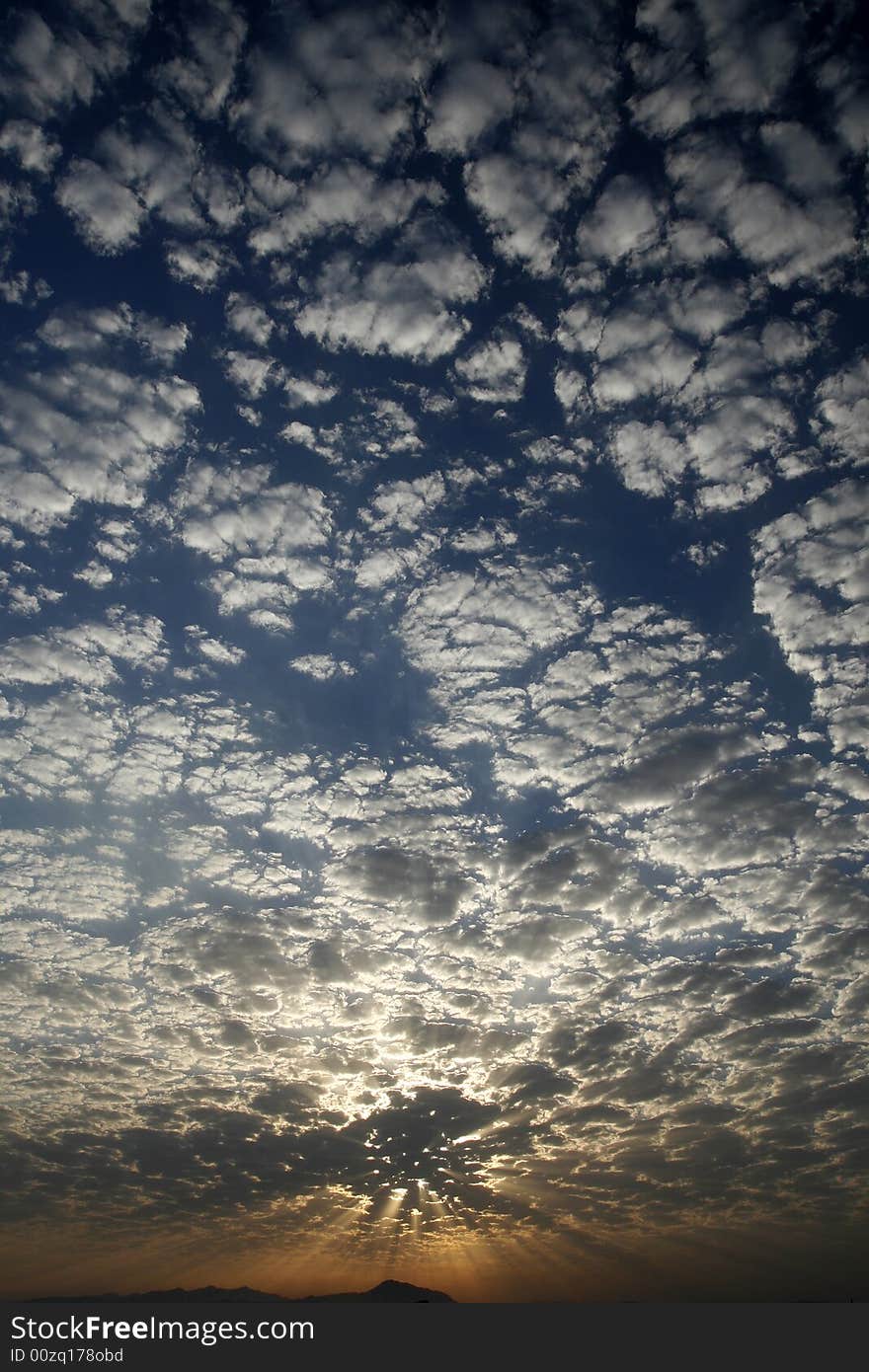 Blue sky with little white clouds at sunset