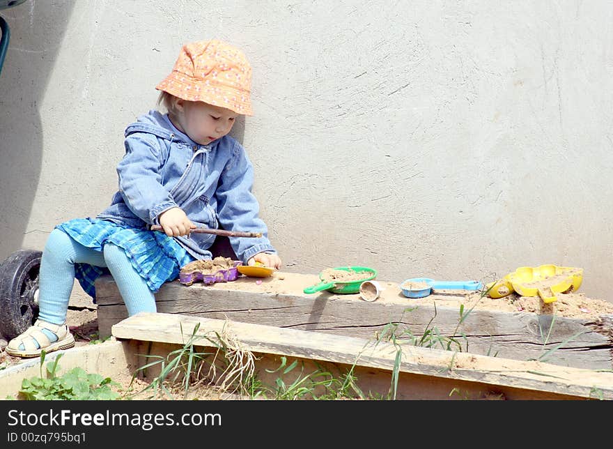 Little girl and sand cakes