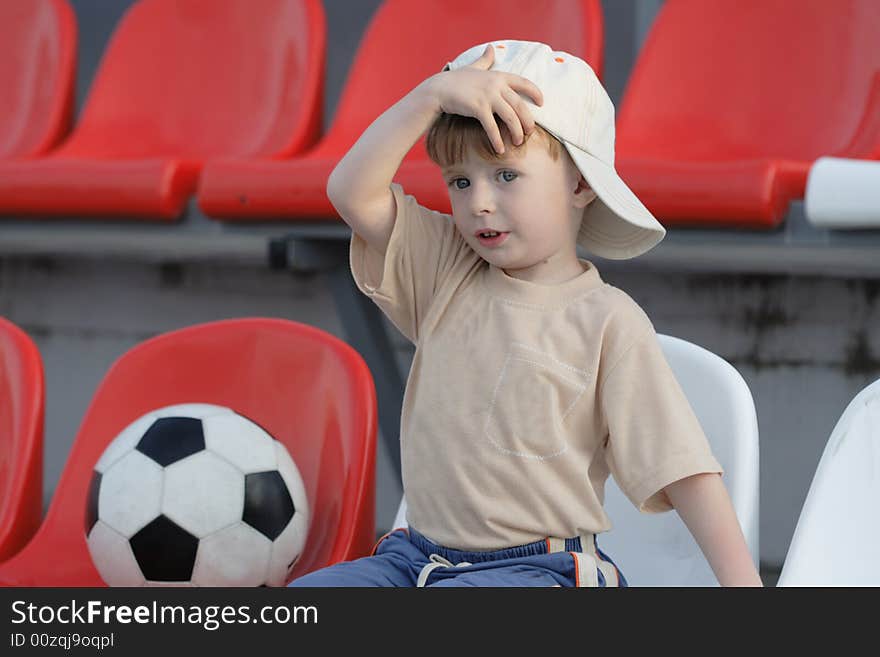 The boy with a toy on empty tribunes of stadium. The boy with a toy on empty tribunes of stadium