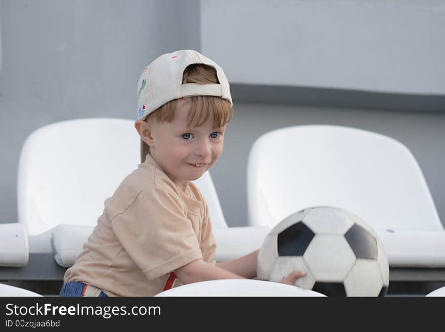 The boy with a toy on empty tribunes of stadium. The boy with a toy on empty tribunes of stadium