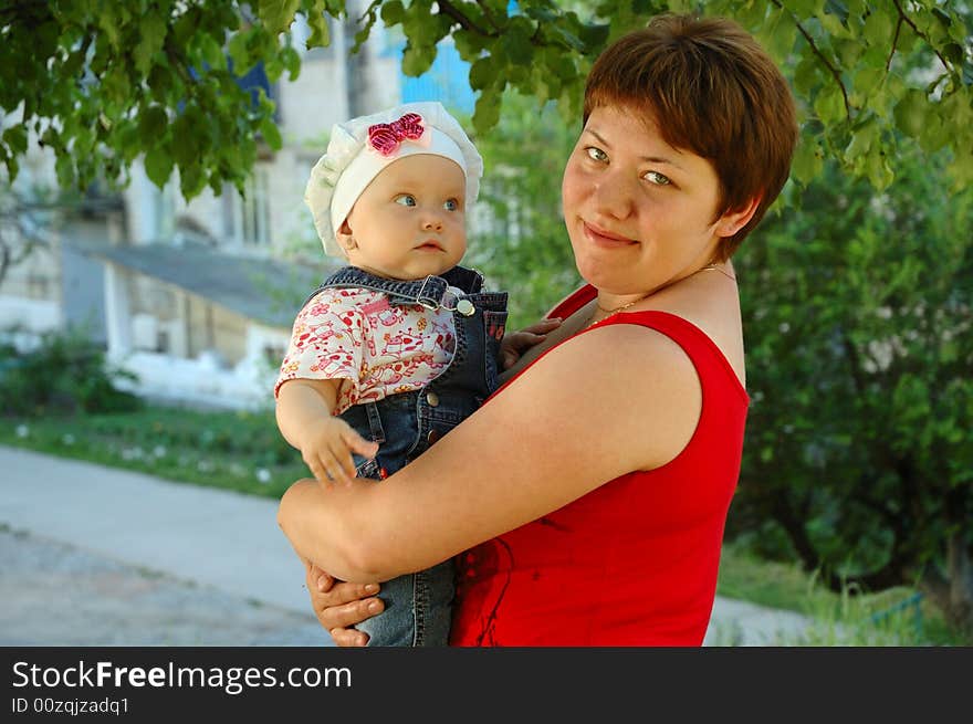 Amazed little girl and her mother on nature background (trees branchlets). Amazed little girl and her mother on nature background (trees branchlets).