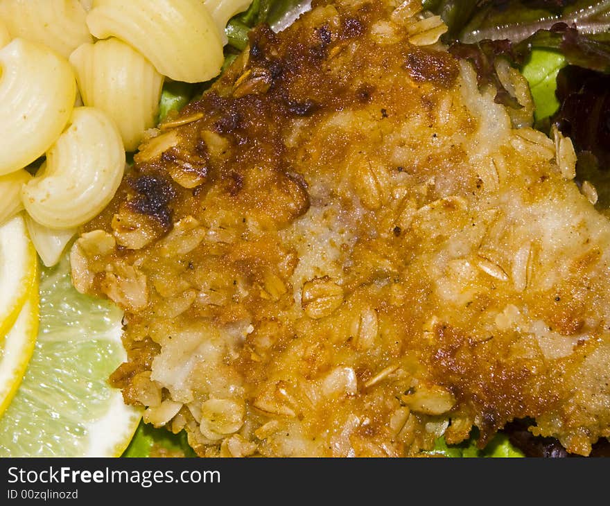 The image of macaroni of a fish and slices of a lemon close up. The image of macaroni of a fish and slices of a lemon close up