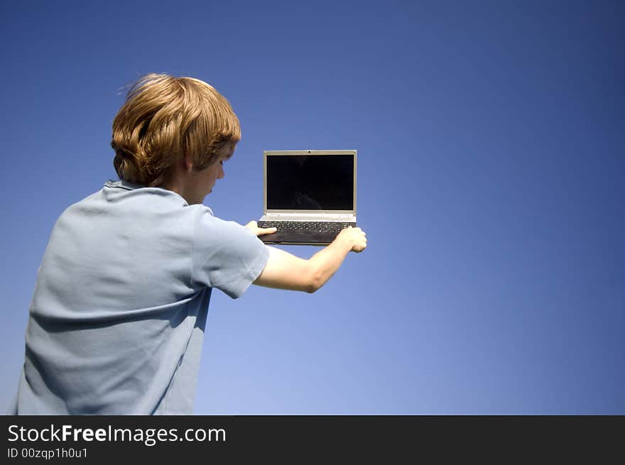 Boy and laptop on sky background