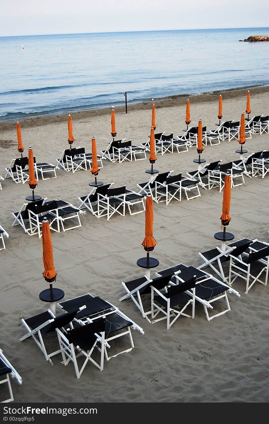 Closed umbrellas on the beach in Laigueglia, Liguria in Italy