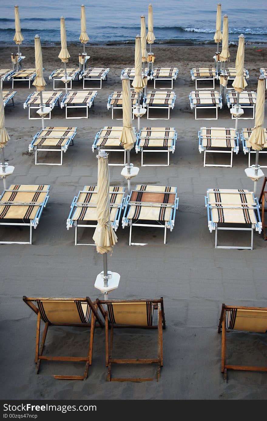 Closed umbrellas on the beach in Laigueglia, Liguria in Italy