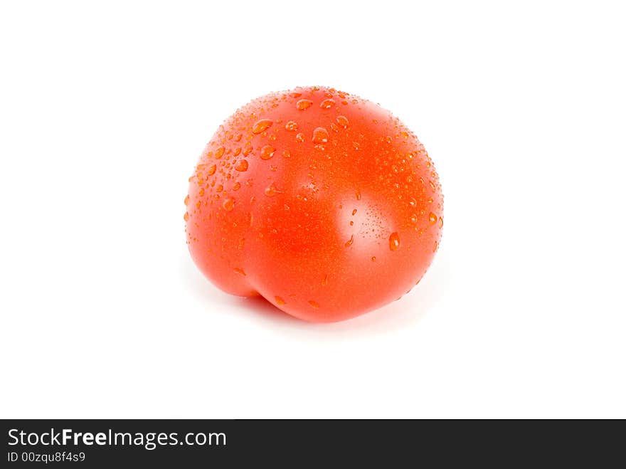 Single ripe tomato with drops of water isolated on the white background