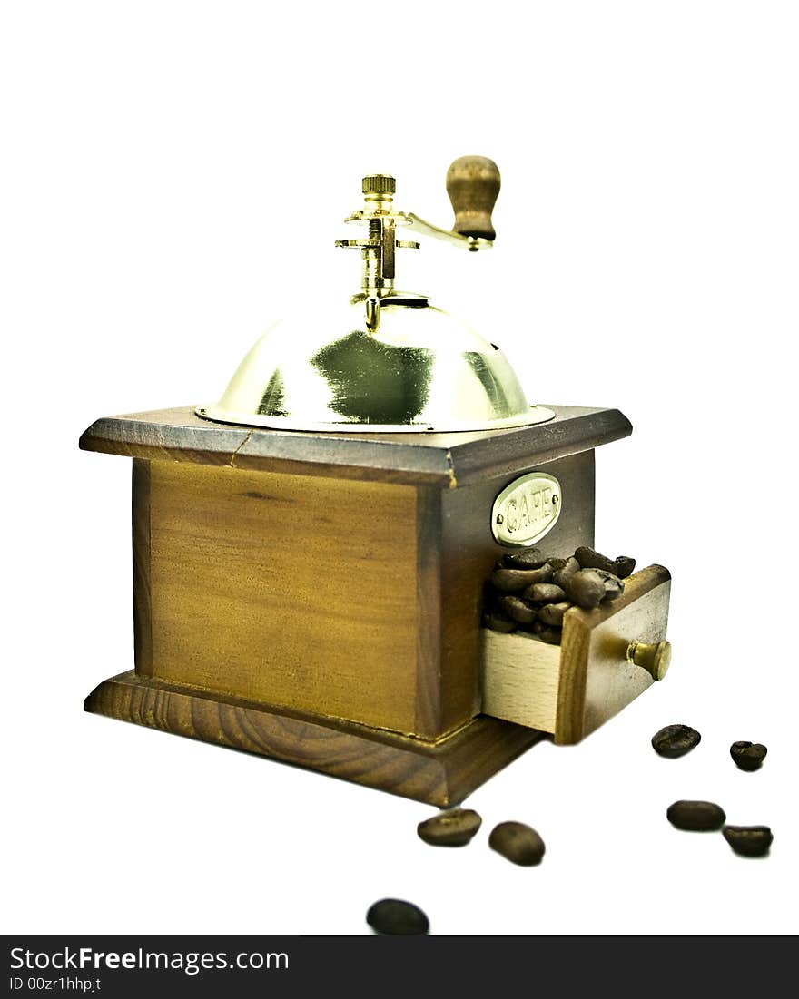 Wooden coffee grinder with coffee grains on a white background