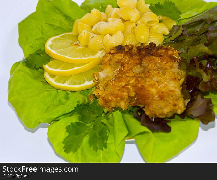 The image of macaroni of a fish and slices of a lemon close up. The image of macaroni of a fish and slices of a lemon close up