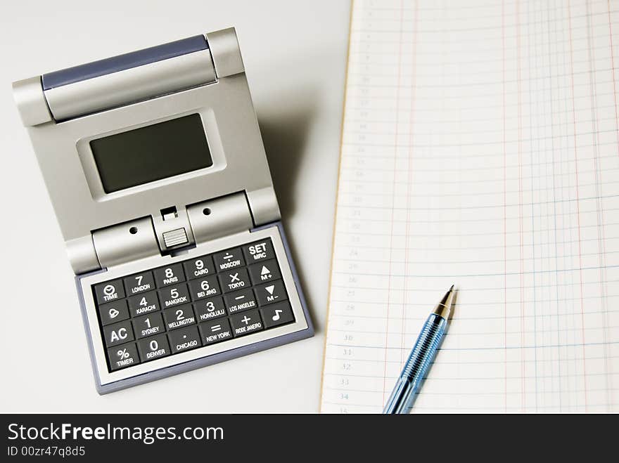 Calculator and alarm clock in one beside ledger