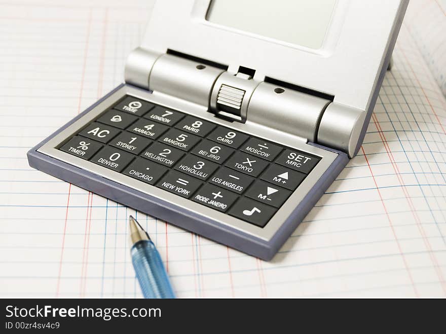 Calculator and alarm clock in one on top of ledger. Calculator and alarm clock in one on top of ledger