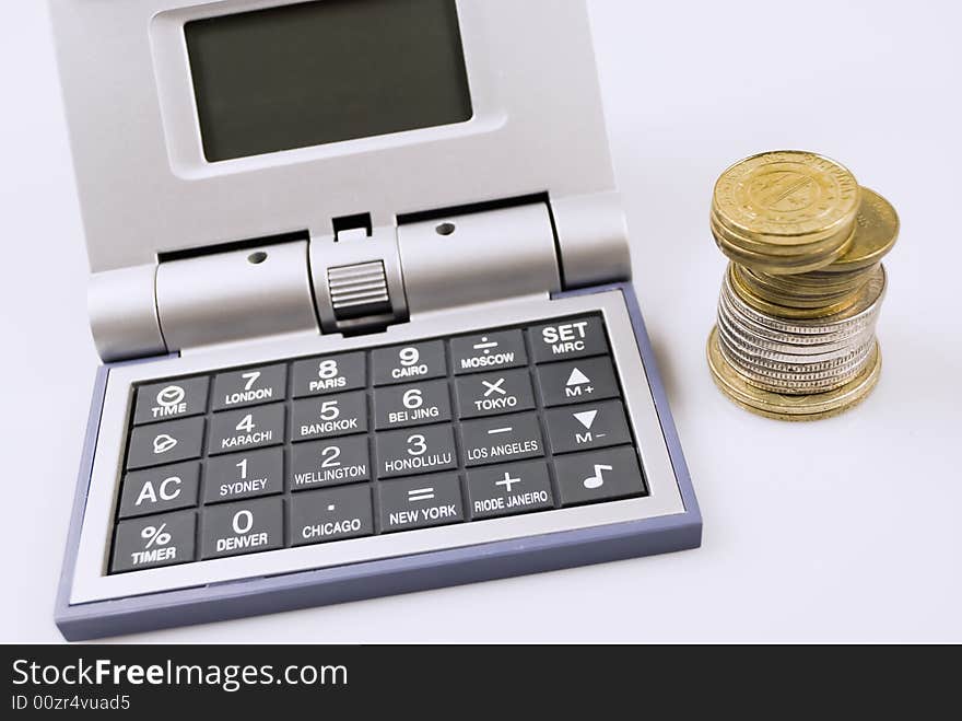 Calculator and alarm clock in one beside coins. Calculator and alarm clock in one beside coins