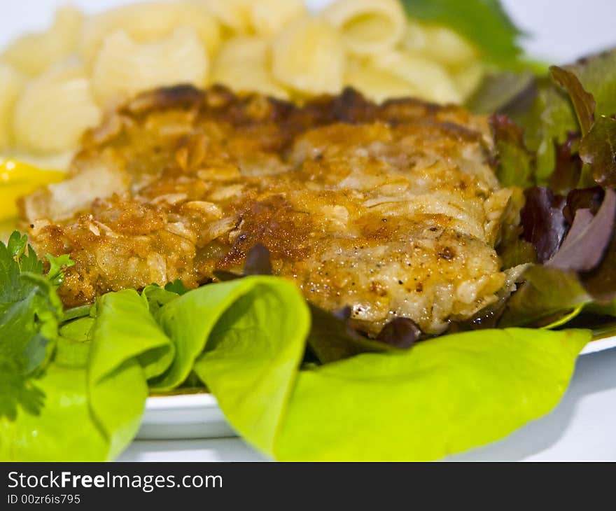 The image of macaroni of a fish and slices of a lemon close up. The image of macaroni of a fish and slices of a lemon close up