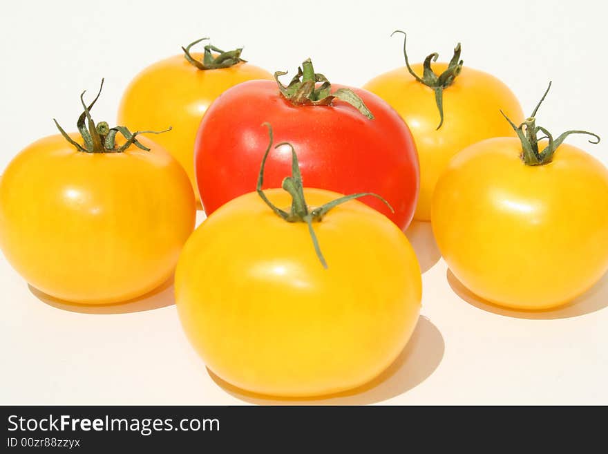 Yellow and red tomatoes against a white background