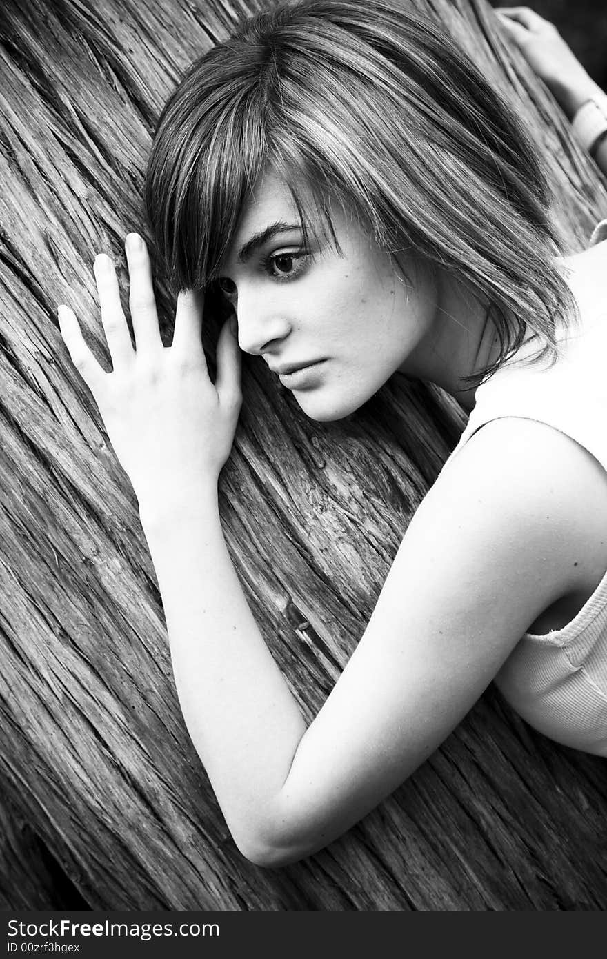 Young woman portrait over a tree trunk