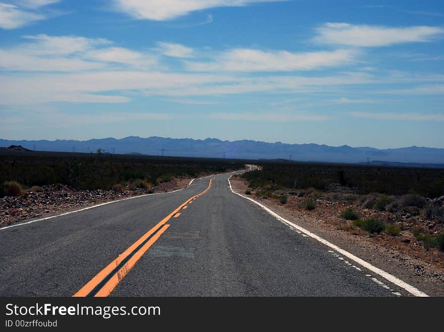 An empty road cuts through the California desert. An empty road cuts through the California desert.