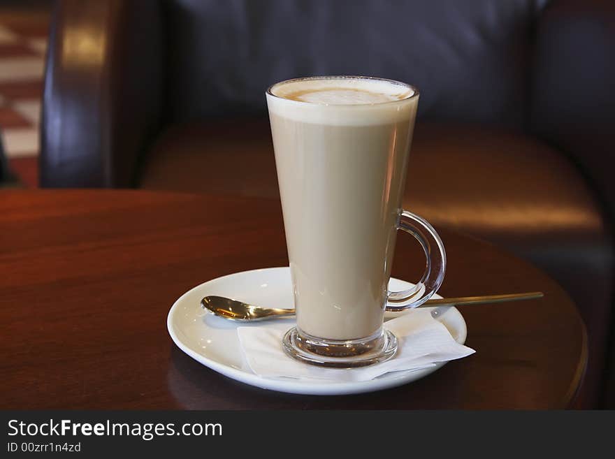 Coffee - Latte Cappuccino in a tall glass on cafe background