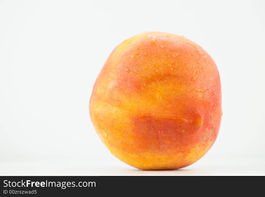 A colourful summer peach isolated on white. A colourful summer peach isolated on white.