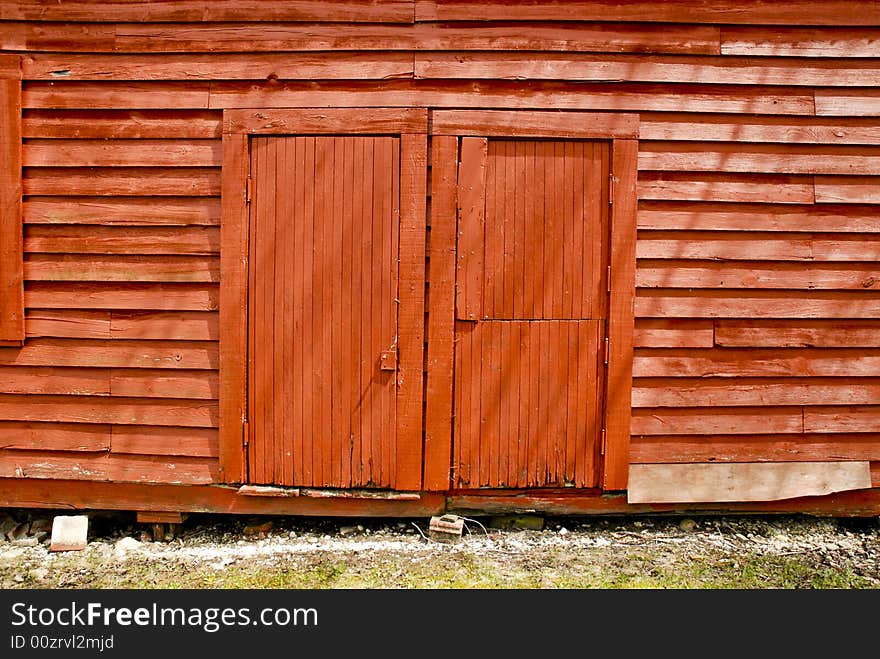 Old, red wooden barn side doors in sunlight. Old, red wooden barn side doors in sunlight