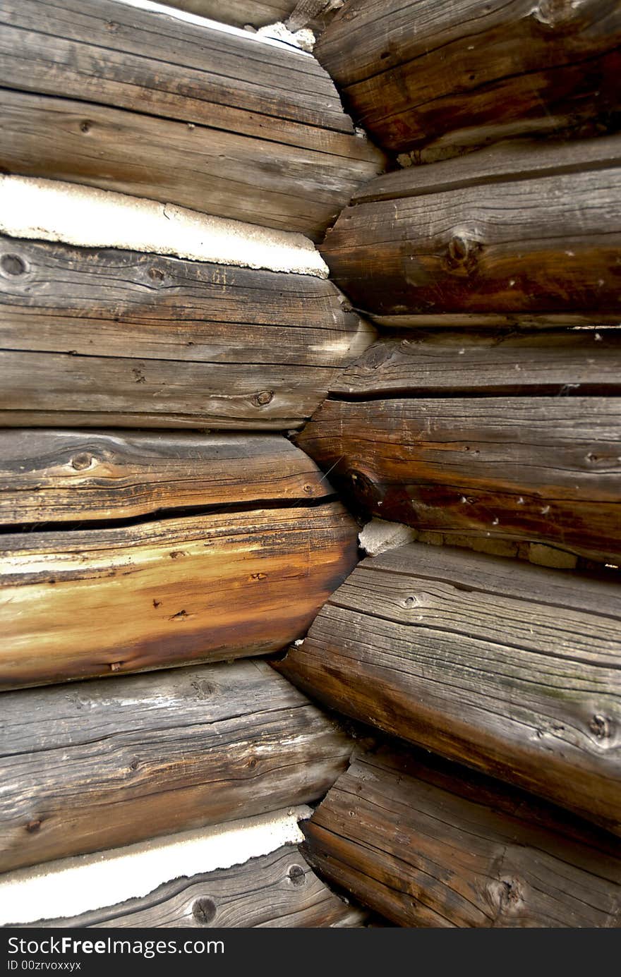 Detail of an old log house exterior corner including weathered look and chipped chinking. Detail of an old log house exterior corner including weathered look and chipped chinking