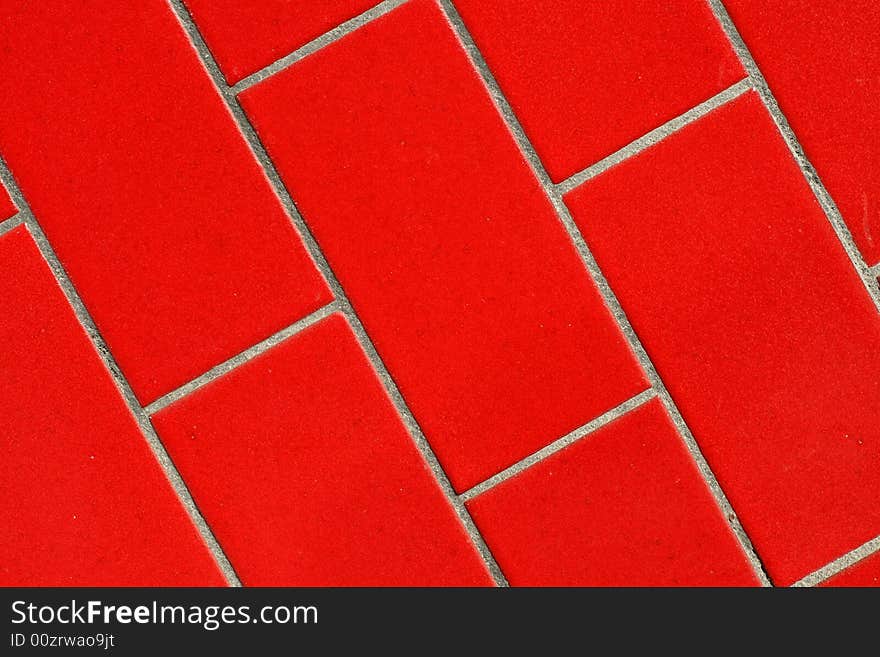 A close up of a red tiled wall.