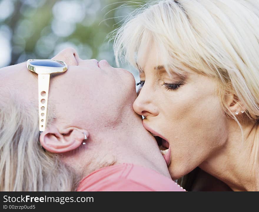 Woman with big eyes kissing a man on the neck. Woman with big eyes kissing a man on the neck