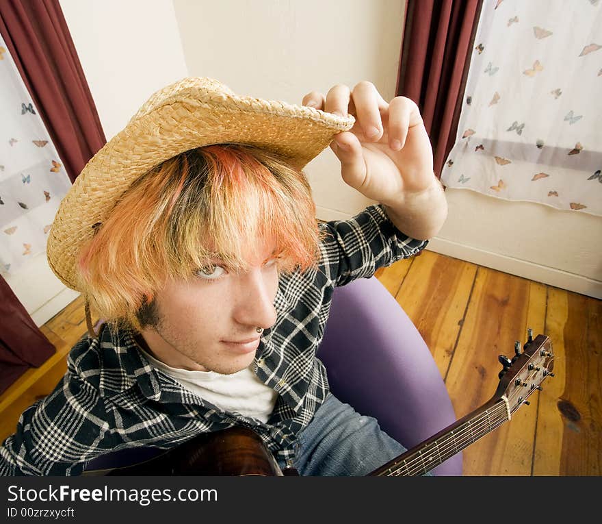 Young musician with an old guitar in an empty room. Young musician with an old guitar in an empty room