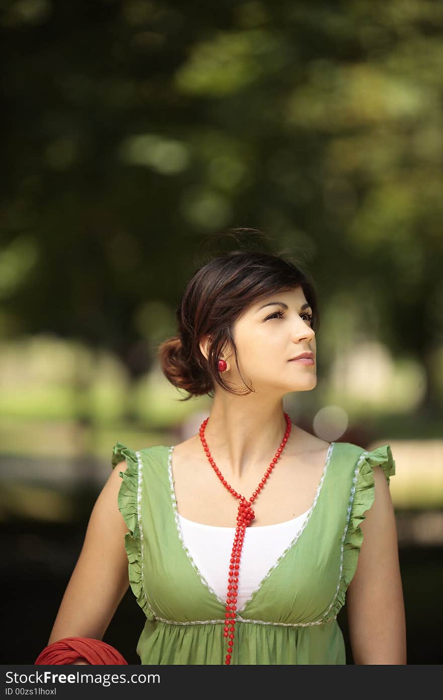 Young lady outdoor looking at the nature around her with a peaceful face. Young lady outdoor looking at the nature around her with a peaceful face