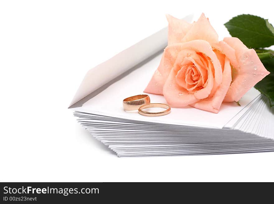 Rose, envelopes and rings on a white background