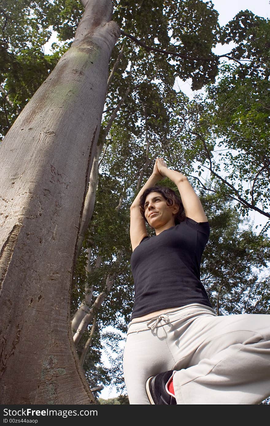 Woman in Yoga Pose Next to Tree in Park - Vertical