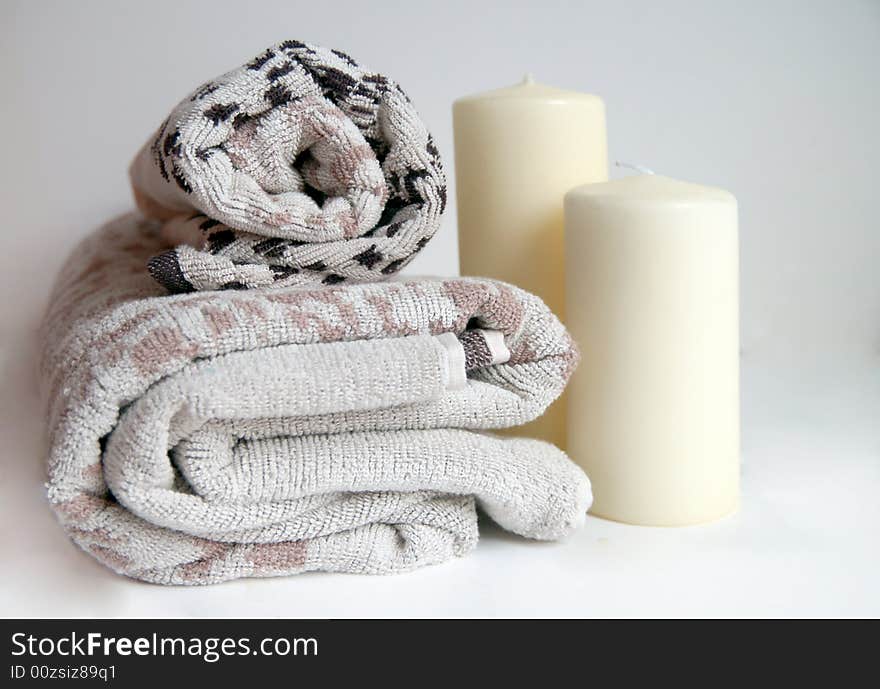 Nordic design towels with a warm beige colour and cream candles for a cleansing and relaxing bath or spa treatment. Nordic design towels with a warm beige colour and cream candles for a cleansing and relaxing bath or spa treatment