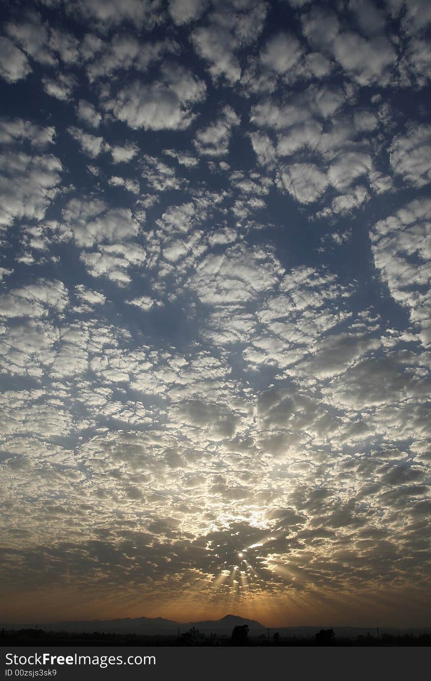 Blue sky with little white clouds at sunset