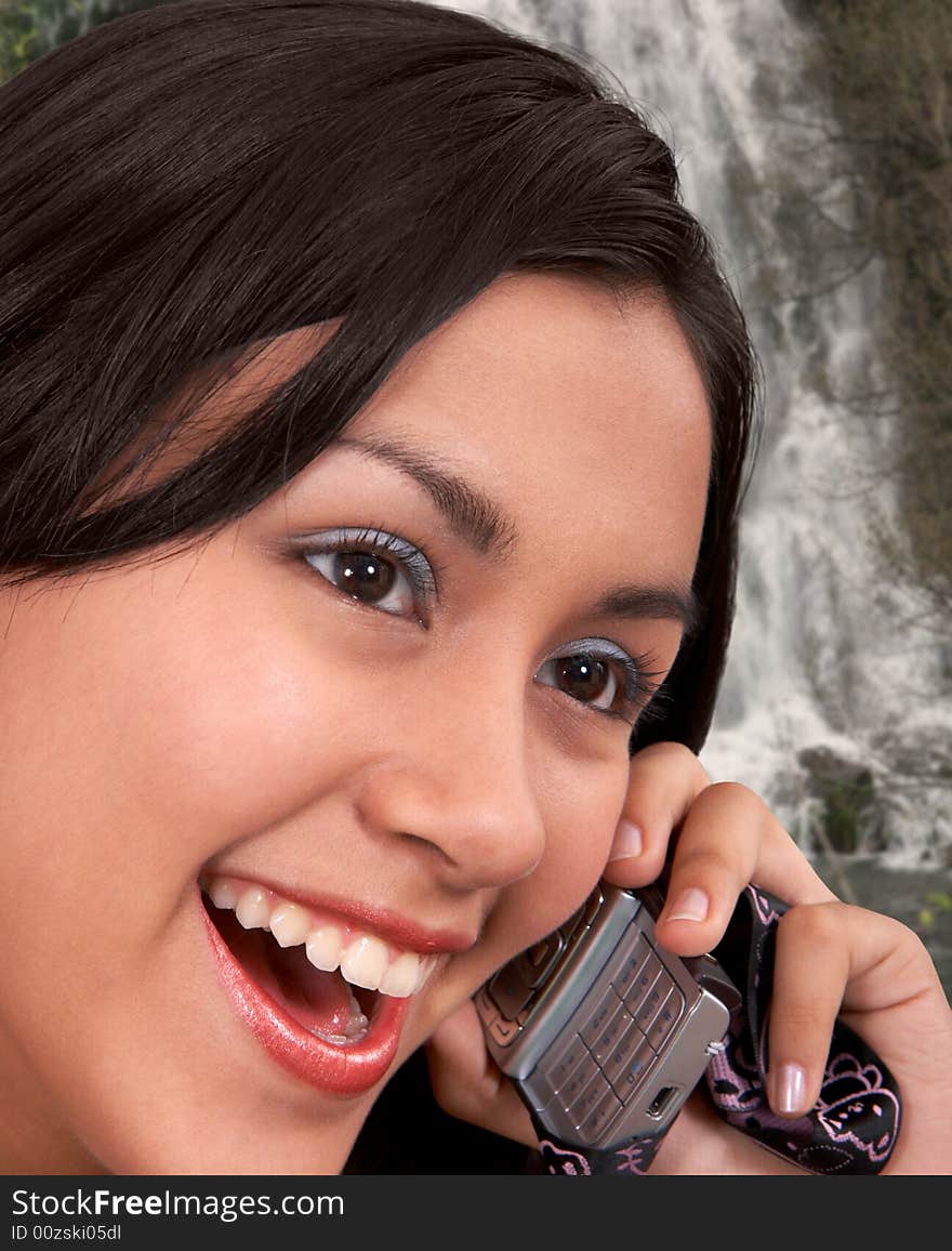 Glamorous girl on phone over the waterfall