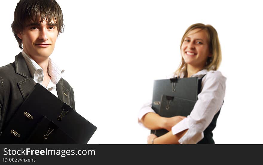 A pretty elegant businesswoman and a young businessman are holding folders. They are wearing elegant white shirts. A pretty elegant businesswoman and a young businessman are holding folders. They are wearing elegant white shirts.