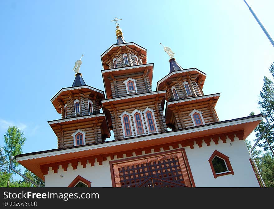 Russian wooden church against the blue sky