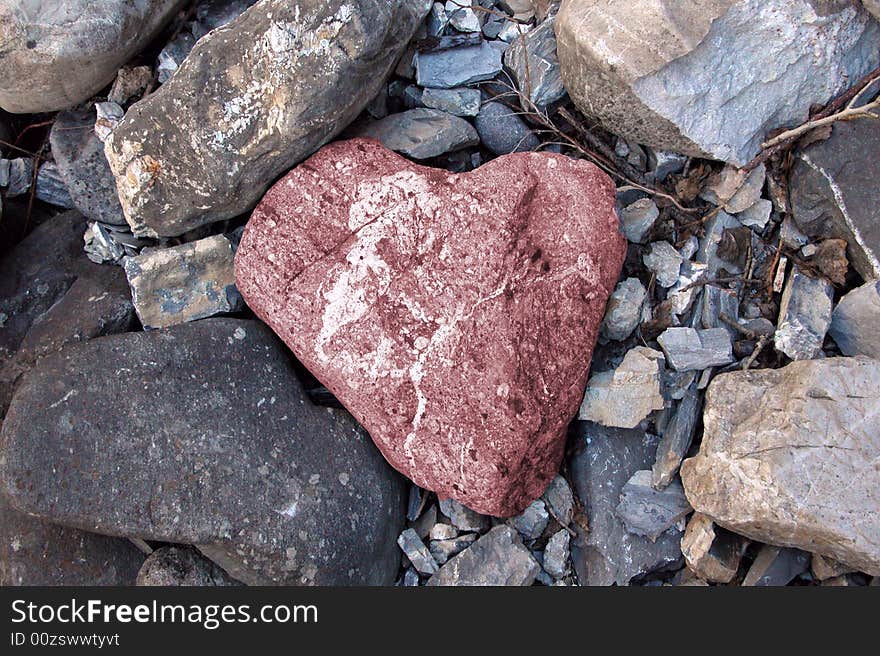 Pink stone in the shape of a heart among rocks. Pink stone in the shape of a heart among rocks