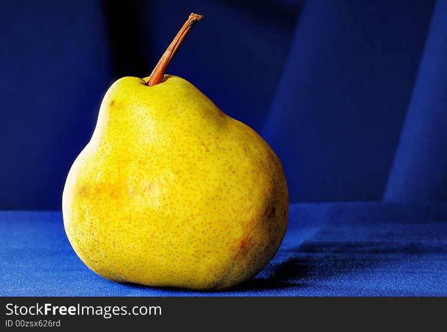 Big yellow pear on the blue draperies. Big yellow pear on the blue draperies.