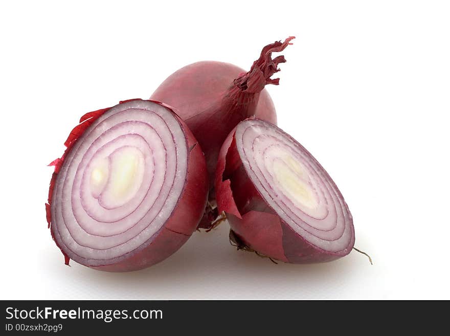 Two red onions on white, one cute in half