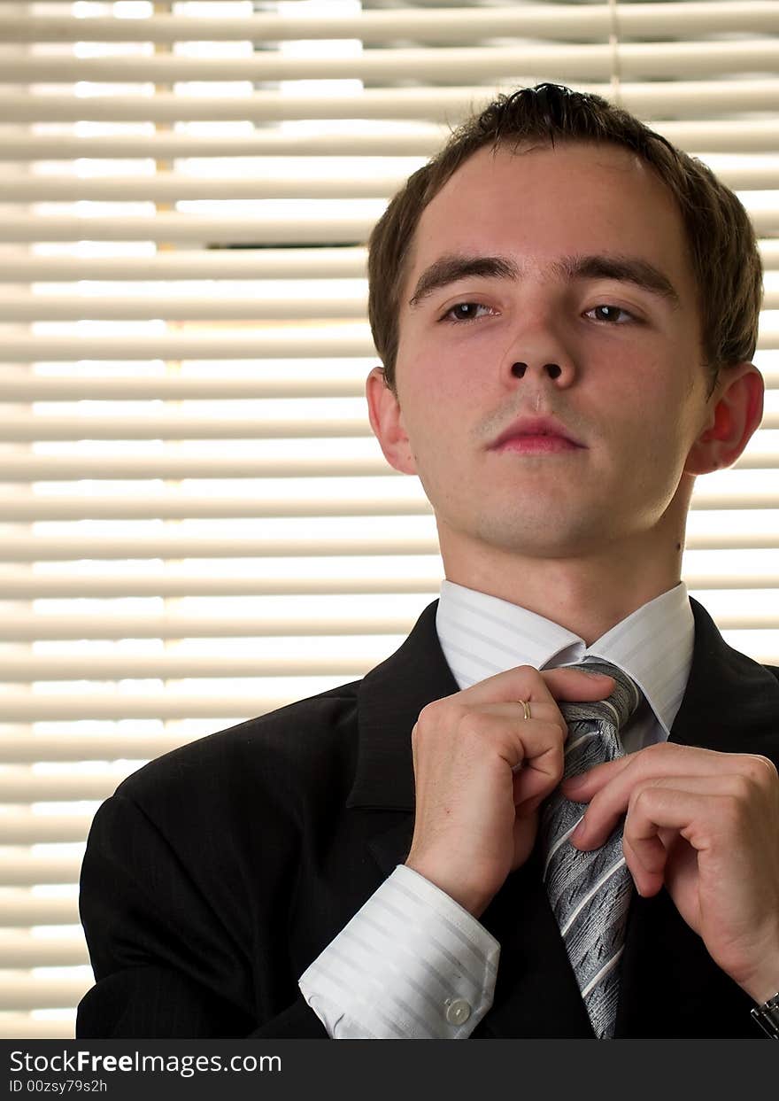 Yound businessman ties necktie