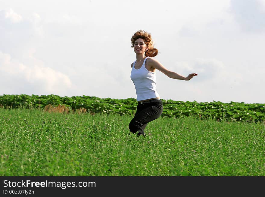 A beautiful girl jumping on the field