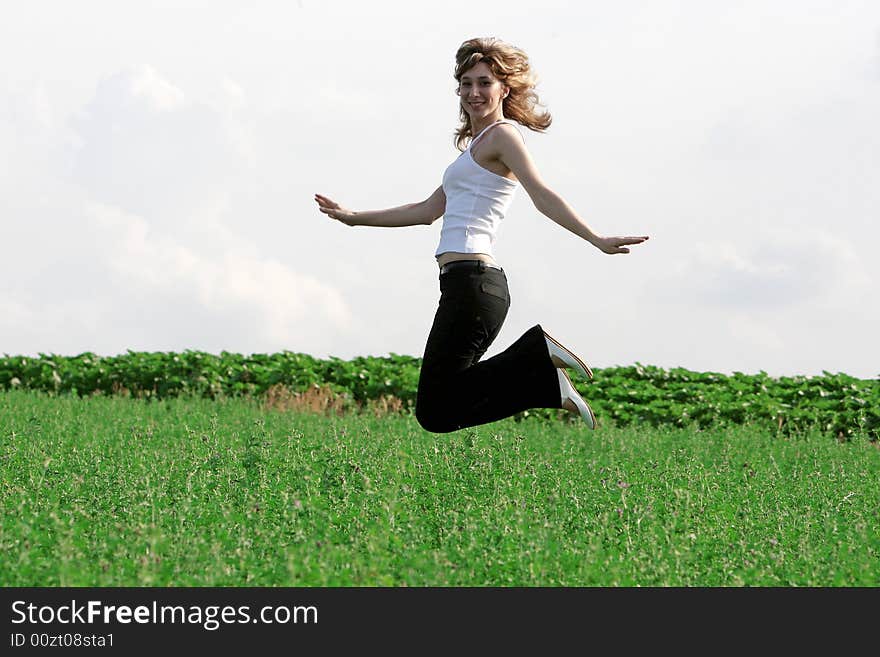 A beautiful girl jumping on the field