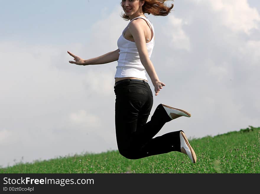 A beautiful girl jumping on the field