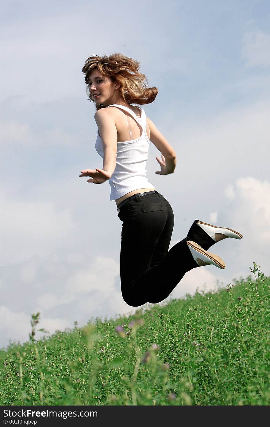 A beautiful girl jumping on the field