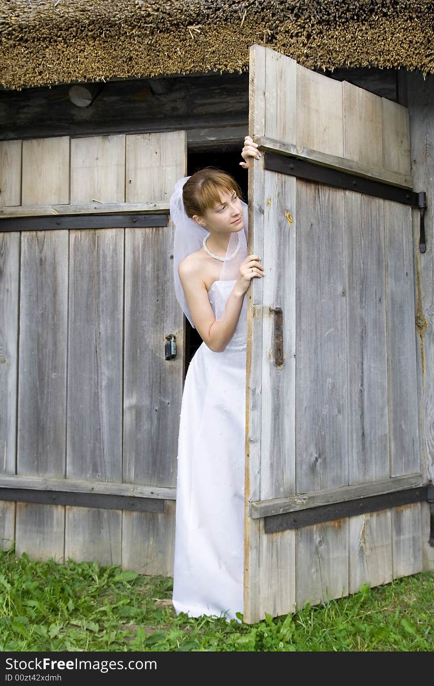 Beautiful bride looks out for a gate