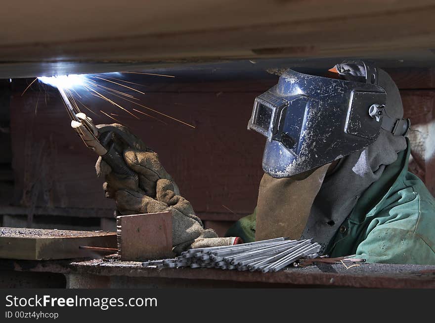 A welder working at shipyard during night shift. A welder working at shipyard during night shift